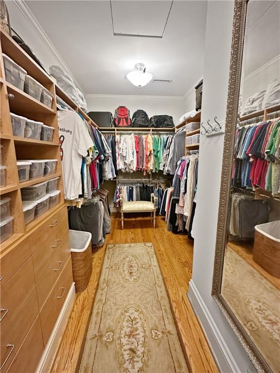 spacious closet featuring attic access and wood finished floors