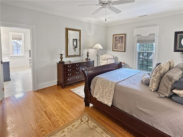 bedroom with light wood-style flooring, crown molding, baseboards, and ceiling fan