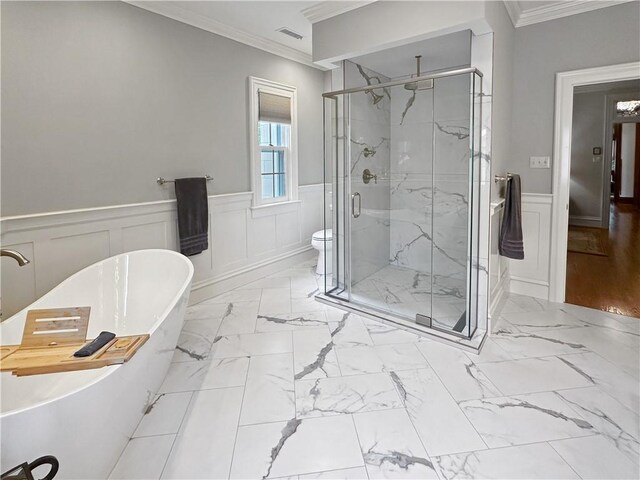 bathroom featuring crown molding, a decorative wall, a stall shower, marble finish floors, and wainscoting