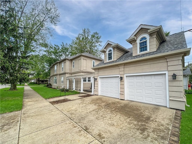 view of front facade with driveway, a front yard, a garage, and a shingled roof
