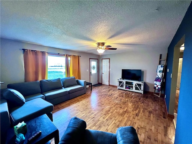 living room with hardwood / wood-style floors, a textured ceiling, and ceiling fan