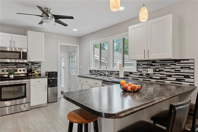 111 W 7th St, Pana, IL 62557 - kitchen with appliances with stainless steel finishes, a sink, dark countertops, backsplash, and recessed lighting