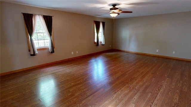 spare room featuring baseboards, a ceiling fan, and wood finished floors
