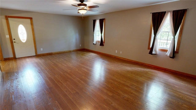 interior space featuring a ceiling fan, plenty of natural light, and wood finished floors