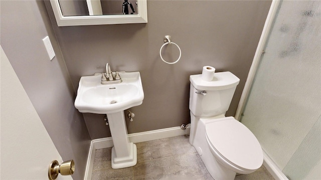 full bath featuring baseboards, a sink, toilet, and a shower stall