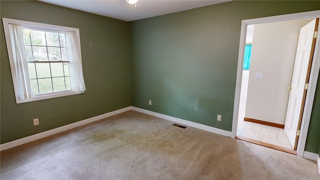 carpeted empty room with baseboards and visible vents