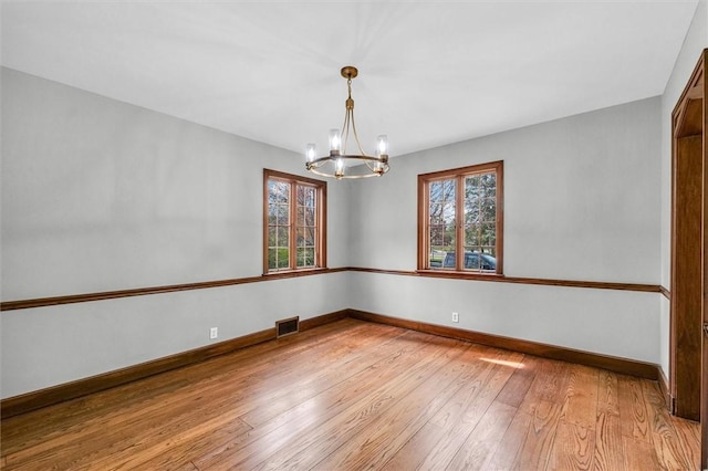 1655 N Vermilion St, Danville, IL 61832 - unfurnished room with light wood-style floors, an inviting chandelier, visible vents, and plenty of natural light