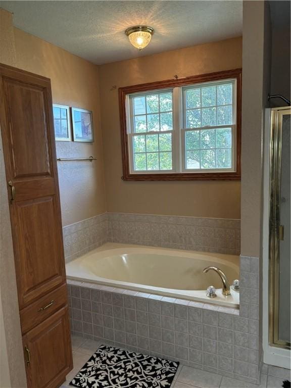 bathroom with tile patterned floors, a shower stall, and a garden tub