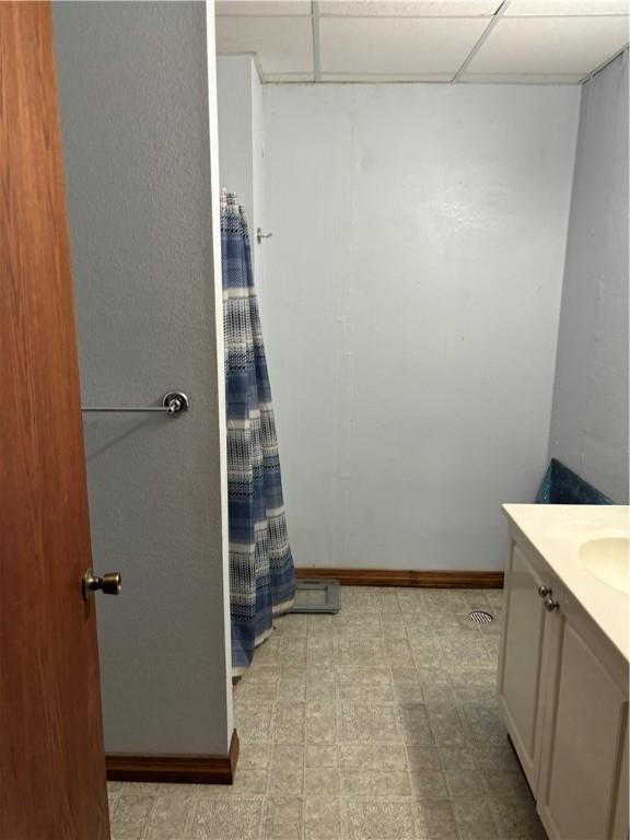 bathroom with vanity, baseboards, a shower with curtain, and tile patterned floors