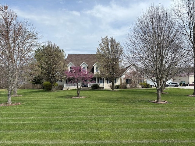 cape cod home featuring a front lawn