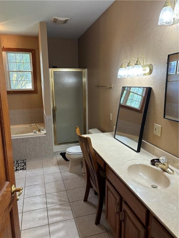 bathroom with tile patterned flooring, vanity, visible vents, toilet, and a shower stall