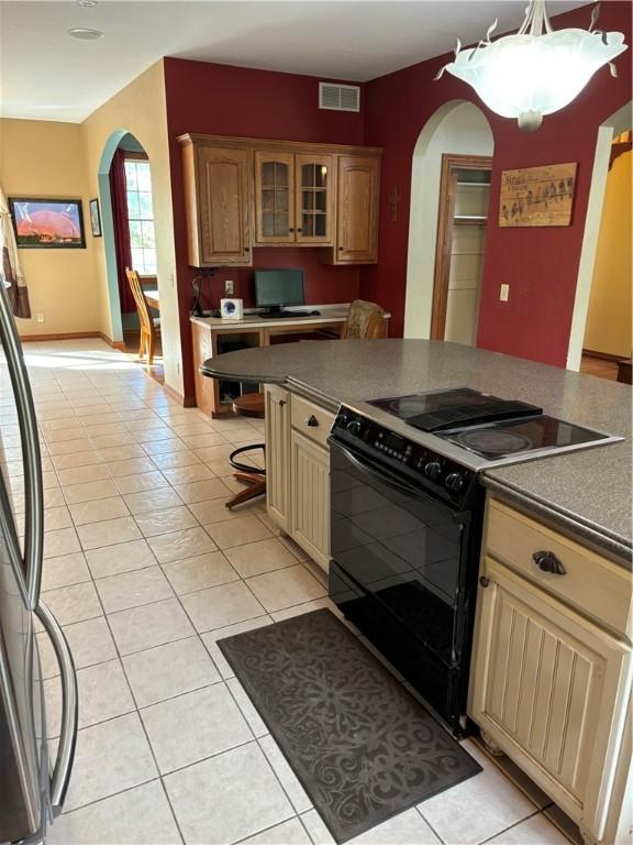 kitchen with arched walkways, visible vents, light tile patterned flooring, and black appliances