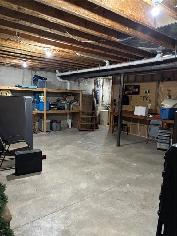unfinished basement featuring stairway and electric panel
