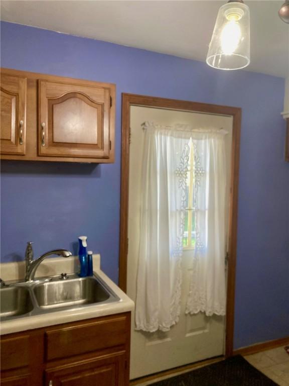 3117 Oak Ave, Mattoon, IL 61938 - kitchen featuring a sink, light countertops, and brown cabinetry