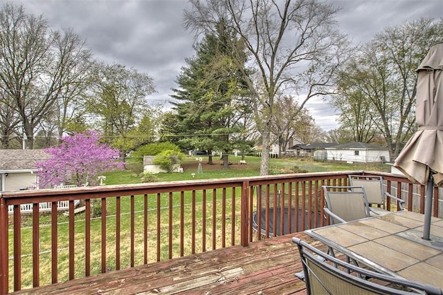 wooden deck featuring a lawn