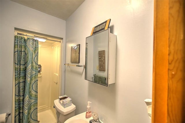 bathroom featuring curtained shower and toilet