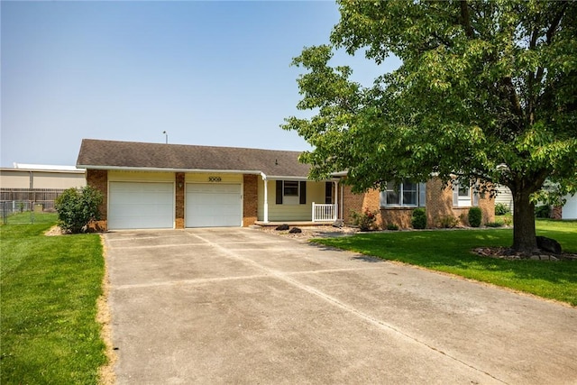 1009 Henrietta St, Effingham, IL 62401 - view of front facade with an attached garage, brick siding, driveway, and covered porch