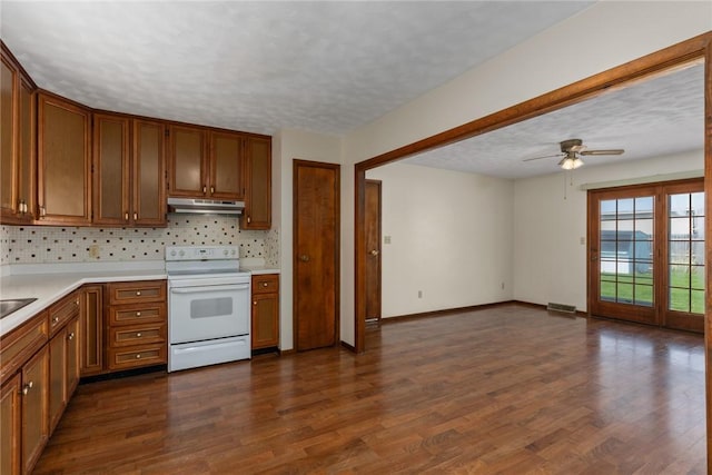 1009 Henrietta St, Effingham, IL 62401 - kitchen featuring white electric stove, under cabinet range hood, ceiling fan, brown cabinetry, and a textured ceiling