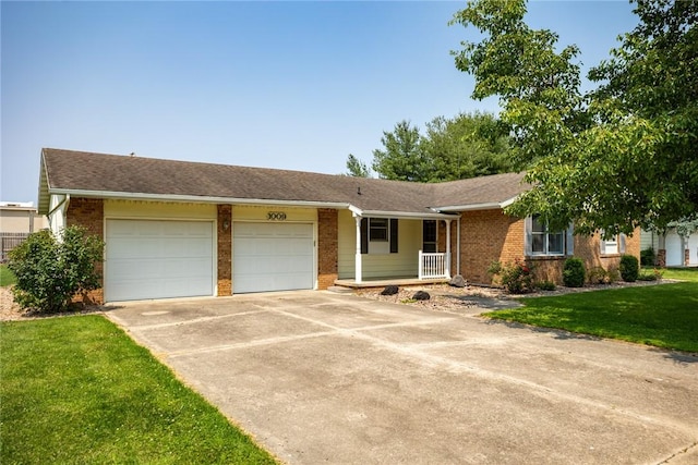 1009 Henrietta St, Effingham, IL 62401 - ranch-style house with brick siding, a garage, driveway, a porch, and a front yard