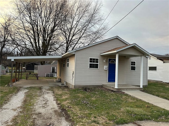 bungalow-style home featuring a front lawn and a carport