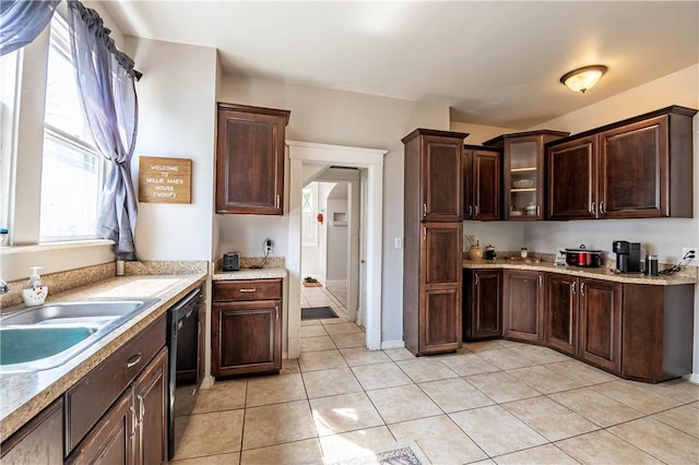 1440 W Decatur St, Decatur, IL 62522 - kitchen with light tile patterned floors, light countertops, dark brown cabinets, black dishwasher, and glass insert cabinets