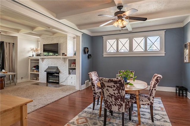 1440 W Decatur St, Decatur, IL 62522 - dining space with wood finished floors, beamed ceiling, ceiling fan, and a brick fireplace