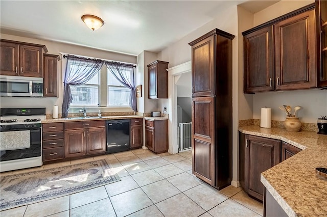 1440 W Decatur St, Decatur, IL 62522 - kitchen with stainless steel microwave, white gas range oven, black dishwasher, dark brown cabinetry, and light tile patterned floors