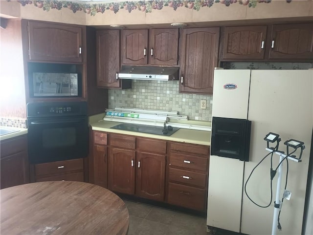 kitchen featuring backsplash, black appliances, dark tile patterned flooring, and dark brown cabinets