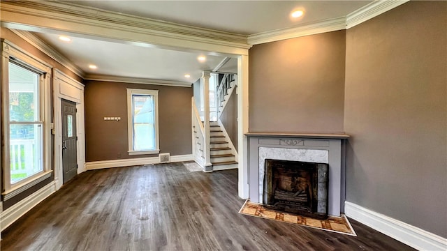 unfurnished living room with dark hardwood / wood-style floors, a wealth of natural light, and crown molding