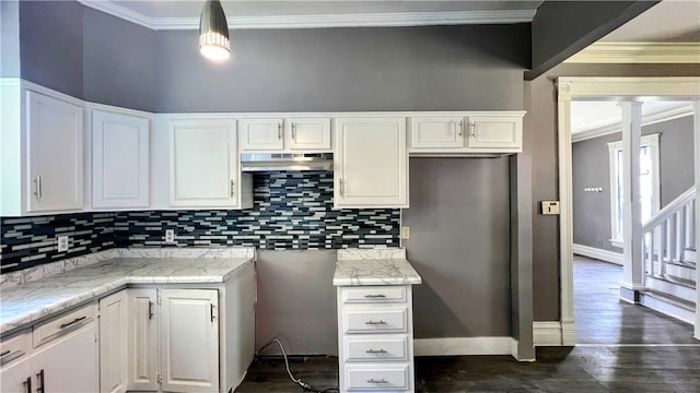 kitchen with white cabinets, decorative backsplash, crown molding, and hanging light fixtures