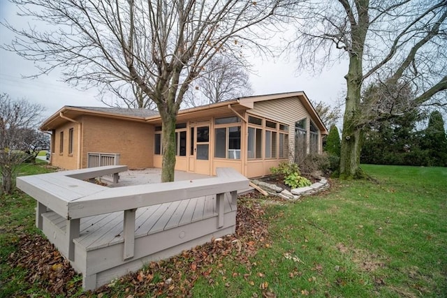 rear view of house with a lawn and a sunroom