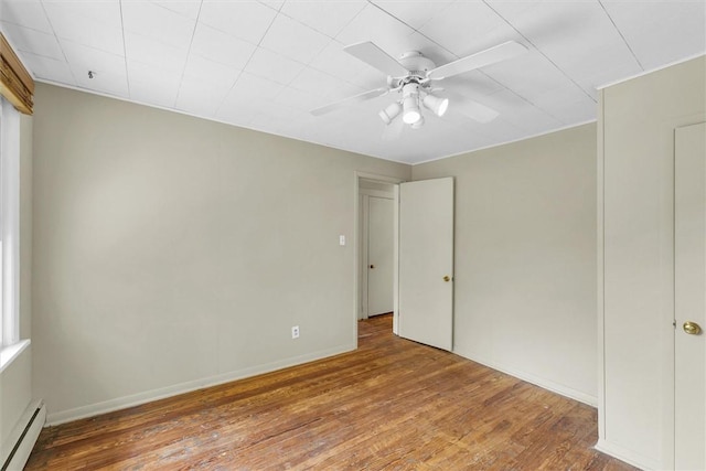 3920 Western Ave, Mattoon, IL 61938 - empty room featuring a baseboard radiator, wood finished floors, and a ceiling fan