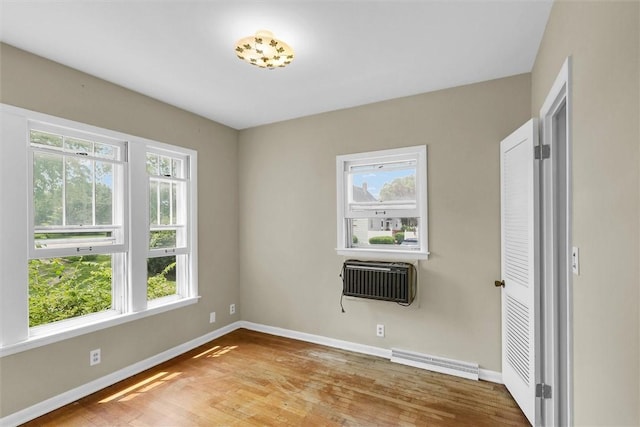 3920 Western Ave, Mattoon, IL 61938 - empty room featuring baseboard heating, wood finished floors, and an AC wall unit