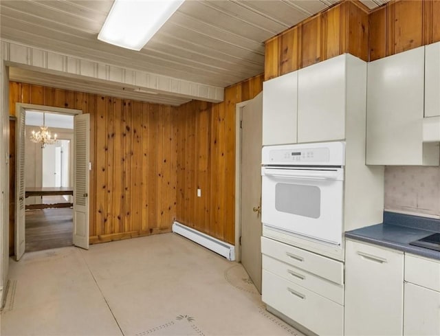 3920 Western Ave, Mattoon, IL 61938 - kitchen with oven, a baseboard heating unit, a chandelier, dark countertops, and white cabinets