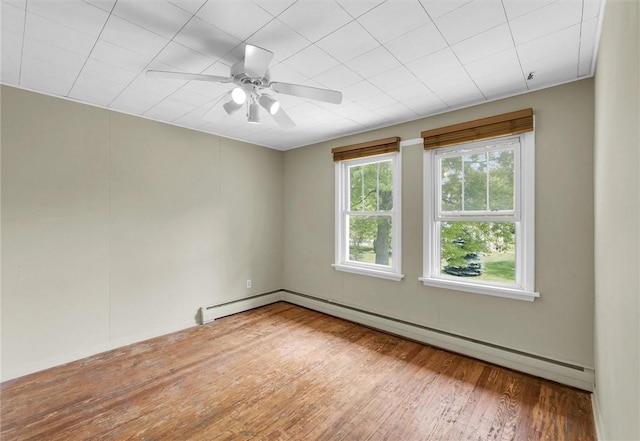 3920 Western Ave, Mattoon, IL 61938 - spare room featuring wood finished floors, a baseboard radiator, and a ceiling fan
