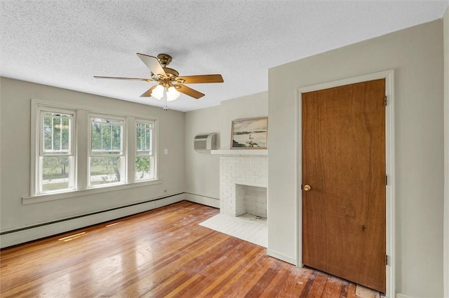 3920 Western Ave, Mattoon, IL 61938 - unfurnished living room featuring wood finished floors, ceiling fan, a textured ceiling, a baseboard heating unit, and a brick fireplace
