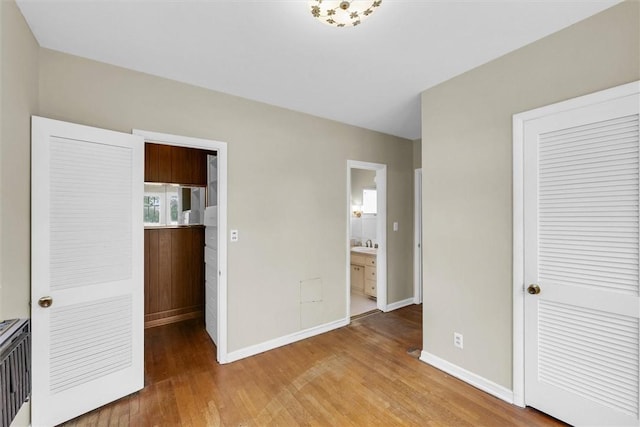 3920 Western Ave, Mattoon, IL 61938 - unfurnished bedroom featuring light wood-style floors, a closet, and ensuite bath