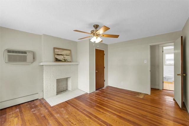 3920 Western Ave, Mattoon, IL 61938 - unfurnished living room featuring a wall mounted air conditioner, a baseboard heating unit, a ceiling fan, wood finished floors, and a textured ceiling