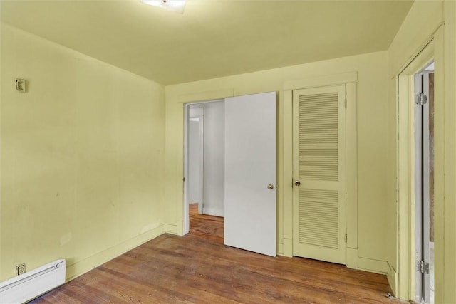 3920 Western Ave, Mattoon, IL 61938 - unfurnished bedroom with baseboard heating, wood finished floors, and a closet