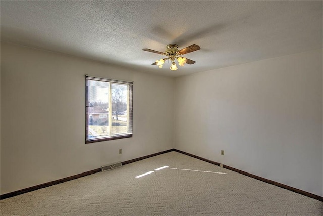 unfurnished room with visible vents, baseboards, a textured ceiling, and carpet flooring