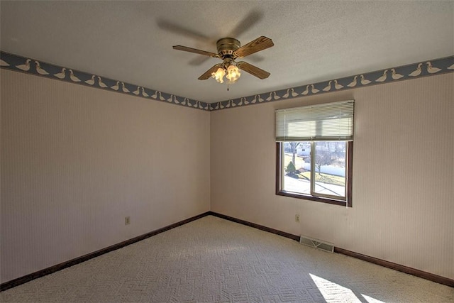 spare room with visible vents, baseboards, carpet, a textured ceiling, and a ceiling fan