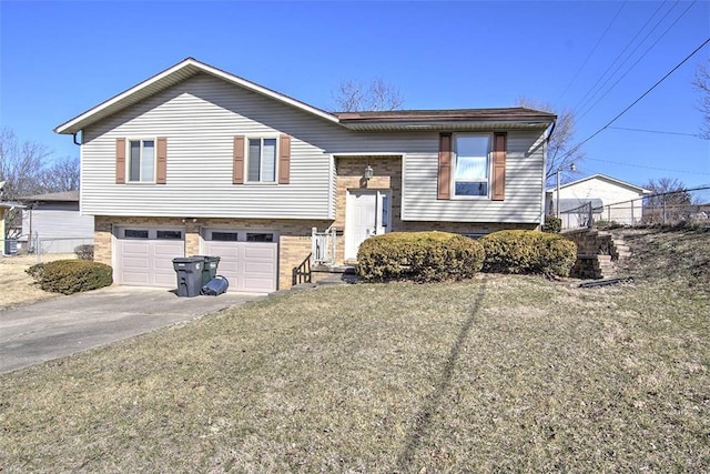 bi-level home with brick siding, an attached garage, concrete driveway, and a front yard