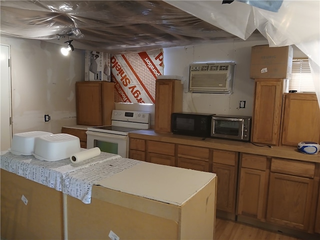 kitchen featuring white range with electric stovetop, light hardwood / wood-style floors, and a wall mounted air conditioner