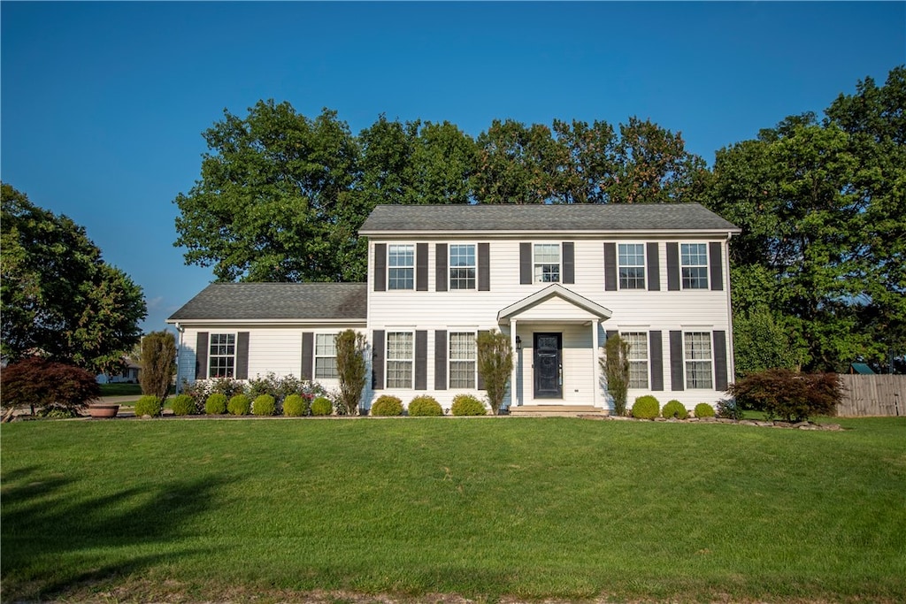 colonial inspired home featuring a front lawn