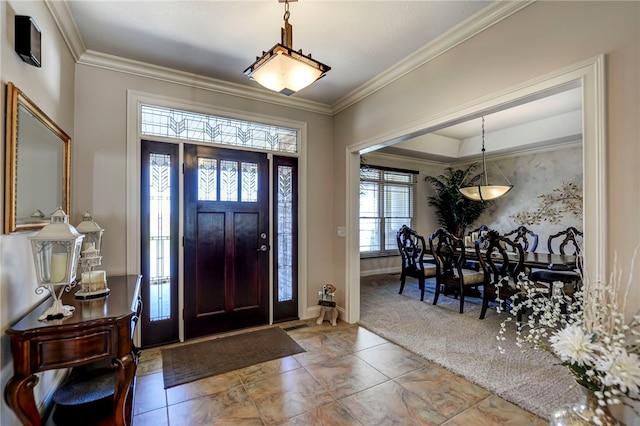 foyer featuring baseboards, carpet flooring, and ornamental molding
