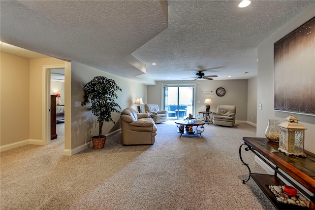 living room featuring baseboards, a textured ceiling, carpet flooring, and a ceiling fan