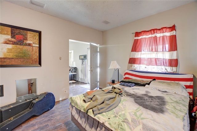 bedroom featuring a textured ceiling and dark wood-type flooring