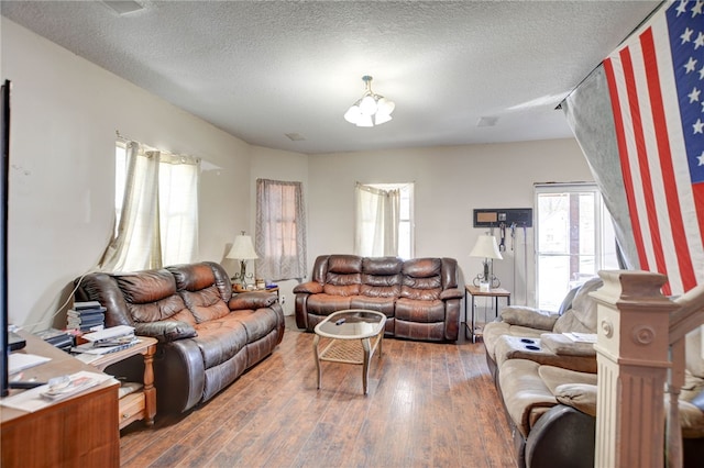 living room featuring a textured ceiling and dark wood-type flooring