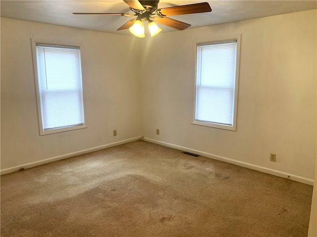 spare room with ceiling fan, a healthy amount of sunlight, and carpet flooring