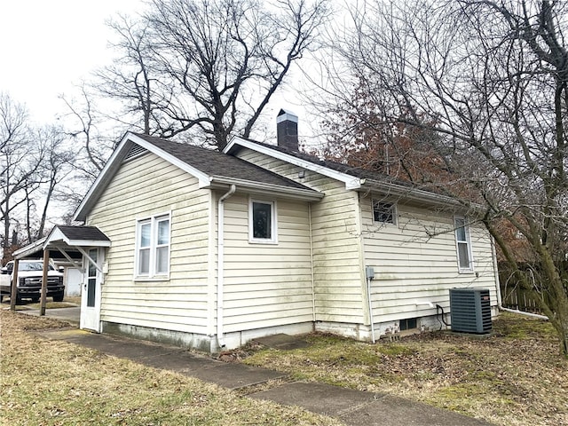 view of side of home with cooling unit and a carport